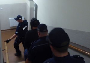 policjanci prowadzą zatrzymanego