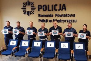 Policjanci trzymają napis: Nasz misja nie ma końca, oddajemy krew dla Wojtka