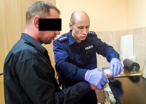 policjant pobiera odciski palców