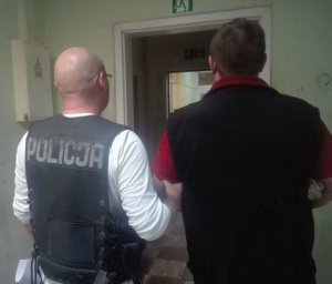 policjant wykonuje czynności z zatrzymanym