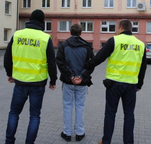 policjanci prowadzą zatrzymanego