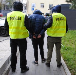 policjanci prowadzą zatrzymanego