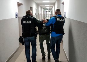 policjanci prowadzą zatrzymanego