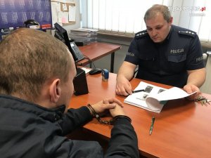 policjant przesłuchuje zatrzymanego