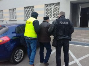 policjanci prowadza zatrzymanego