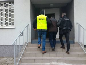 policjanci prowadza zatrzymanego