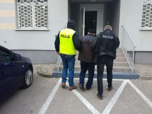 policjanci prowadza zatrzymanego