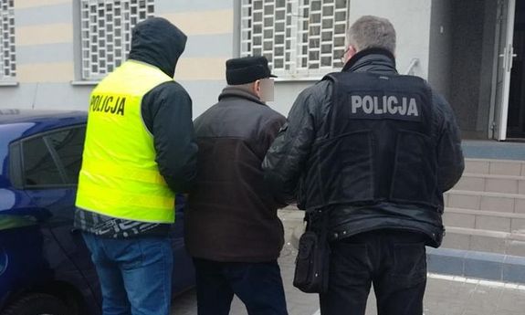 policjanci prowadzą zatrzymanego