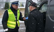 policjant wręcza kierowcy ulotkę
