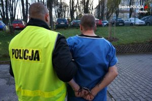 policjant prowadzi zatrzymanego