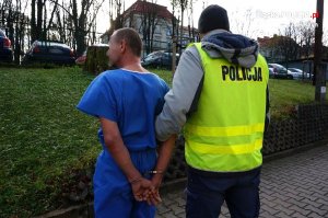 policjant prowadzi zatrzymanego