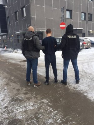 policjanci prowadzą zatrzymanego