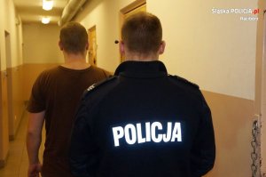 policjant prowadzi zatrzymanego