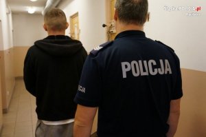 policjant prowadzi zatrzymanego