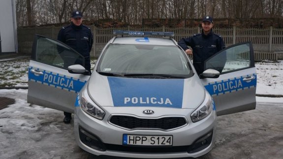 Policjanci na tle radiowozu