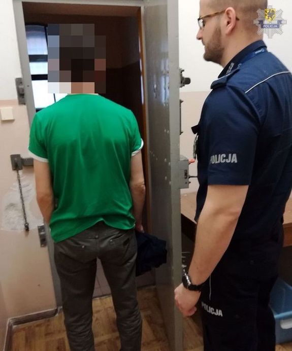 policjant prowadzi zatrzymanego