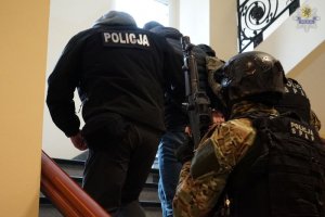 policjanci prowadzą zatrzymanego
