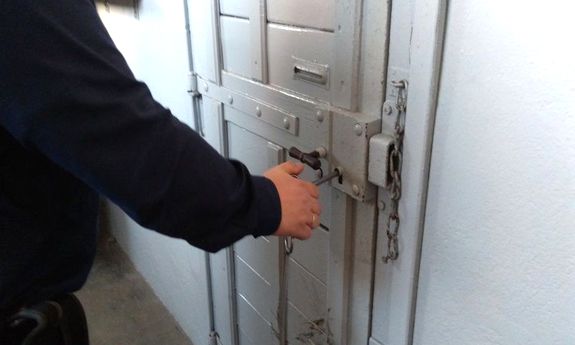 policjant zamyka drzwi do celi