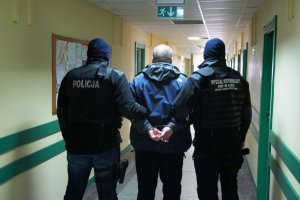 policjanci prowadzą zatrzymanego