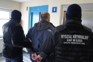 policjanci prowadzą zatrzymanego