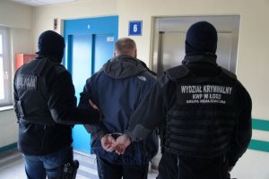 policjanci prowadzą zatrzymanego