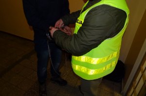 policjant prowadzi zatrzymanego