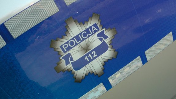 policyjna odznaka na radiowozie z napisem Policja i 112