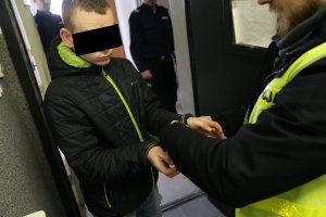 policjant prowadzi zatrzymanego