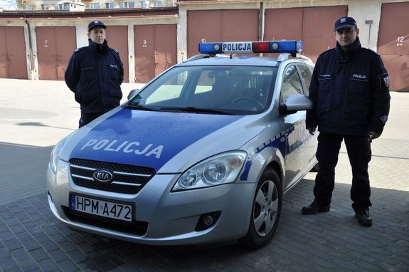 policjanci na tle radiowozu