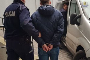 policjanci prowadzą zatrzymanego