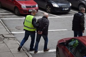 policjant prowadzi zatrzymanego