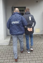 policjant prowadzi zatrzymanego