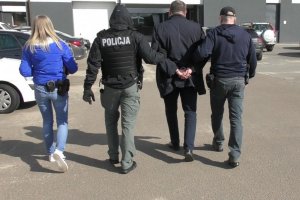 policjanci prowadzą zatrzymanego