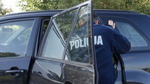 policjant przy zatrzymanym samochodzie