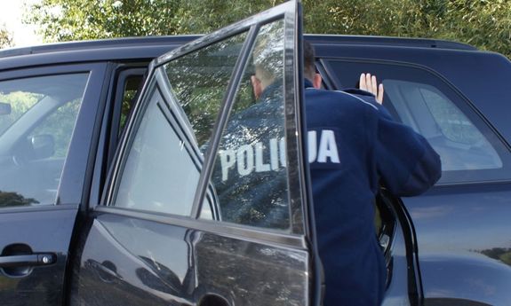 policjant przy zatrzymanym samochodzie