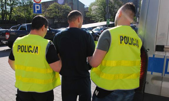 policjanci prowadzą zatrzymanego