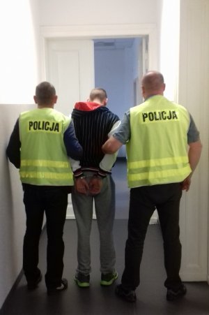 policjanci prowadzą zatrzymanego