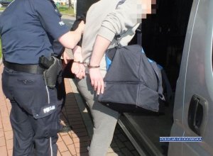 policjanci prowadzą zatrzymanego