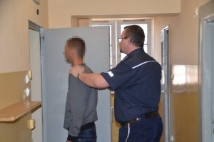 policjant prowadzi zatrzymanego