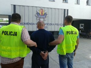 policjanci prowadzą zatrzymanego