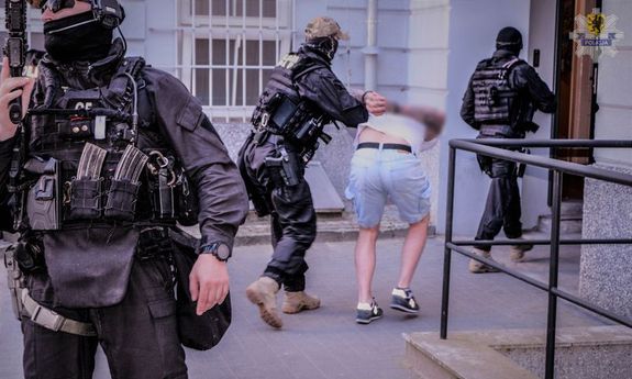 policjanci prowadzą zatrzymanego