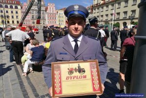 Policjant odbierający nagrodę.