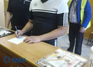 policjant prowadzi czynności z zatrzymanym