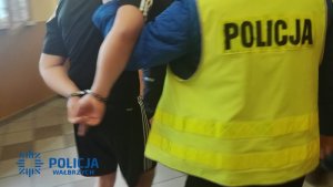 policjant prowadzi zatrzymanego