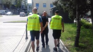 policjanci prowadzą zatrzymanego