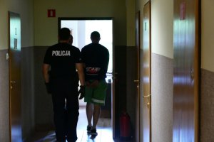 policjant prowadzi zatrzymanego