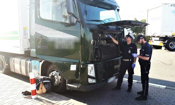 policjanci wykonują czynności przy odzyskanym samochodzie ciężarowym