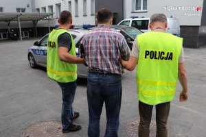 policjanci prowadzą zatrzymanego