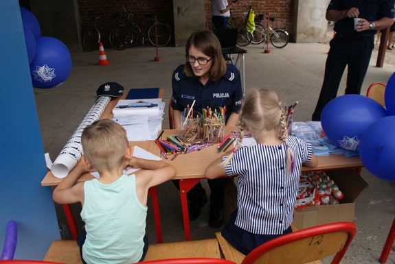 dzieci rozwiązuja zagadki pod okiem policjantki