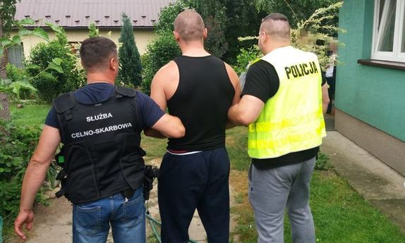 policjanci prowadzą zatrzymanego